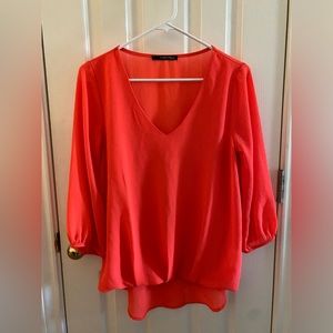 Caramels bright orange flowing top with pearl cuff buttons